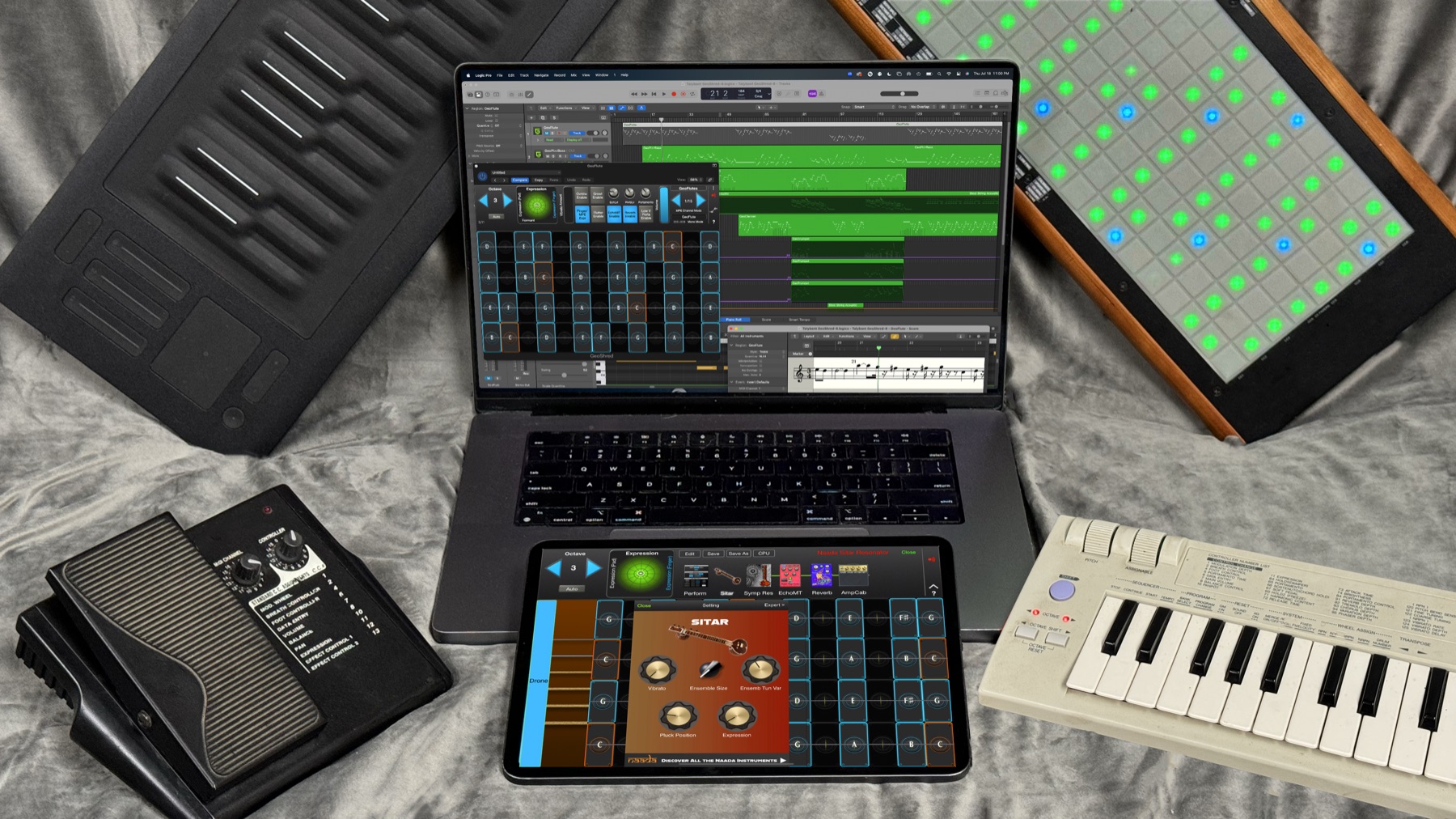 GeoShred Studio running in Logic Pro on a MacBook Pro and on an iPad, surrounded by MPE and MIDI controllers, an expression pedal and a breath-controller keyboard